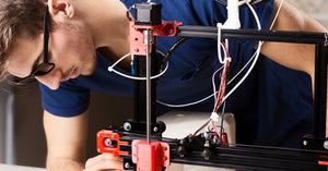 A young creative adjusting the settings on his 3D printer to prevent heat creep from complicating his finished product.