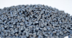 A close-up of a small pile of black carbon fiber pellets ready for use in chopped 3D printing applications.